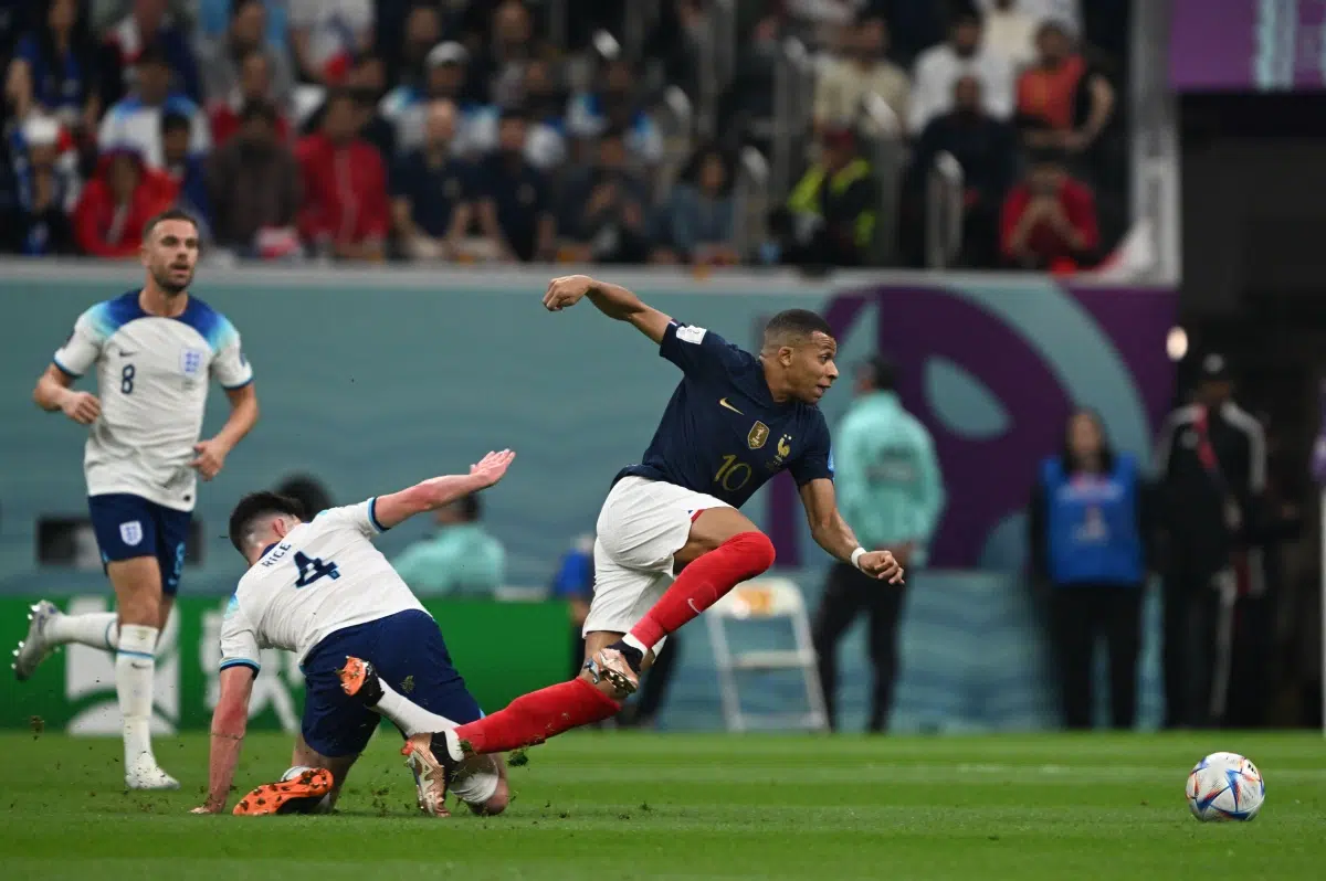 Kylian Mbappé (France) wins a footrace against England's Declan Rice during their quarter-final bout in Qatar