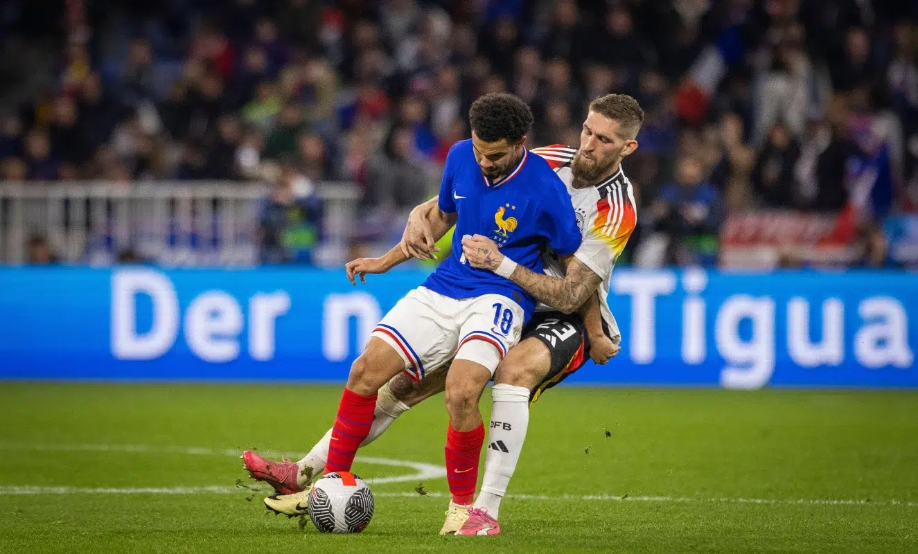 Warren Zaïre-Emery controlling the ball in front of Robert Andrich in Lyon.